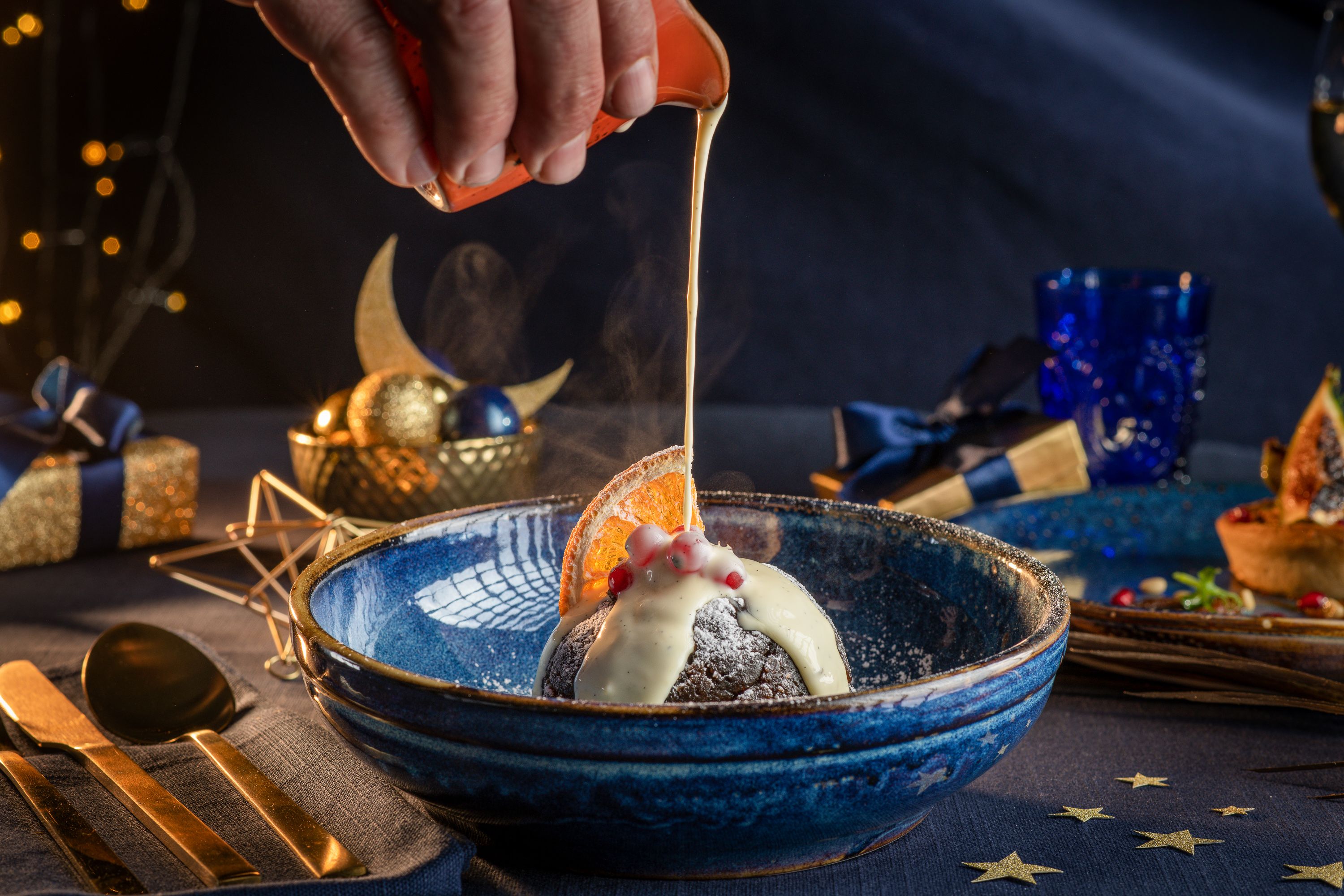 Cream being drizzled on a Christmas pudding