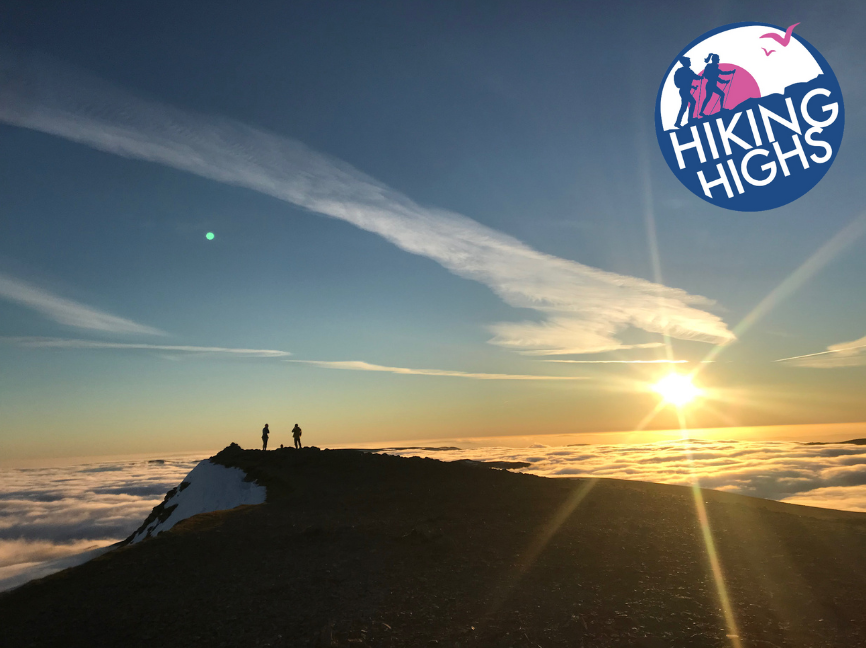 People walking up a mountain at sunset